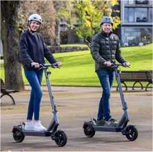 Menschen auf E-Scooter mit Helm